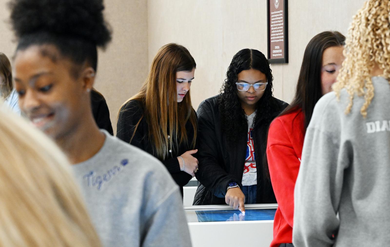 Students visiting the MSU-Meridian PA program and viewing anatamoge table.