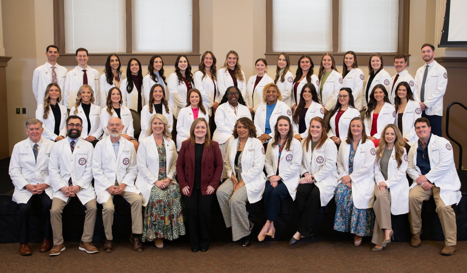 PHOTO ID: Mississippi State University-Meridian Master of Physician Assistant Studies students gather with faculty for a formal photograph following a spring White Coat Ceremony signaling the students are ready to leave the didactic phase of their education and enter clinical rotations. (Photo by Mark Davis)