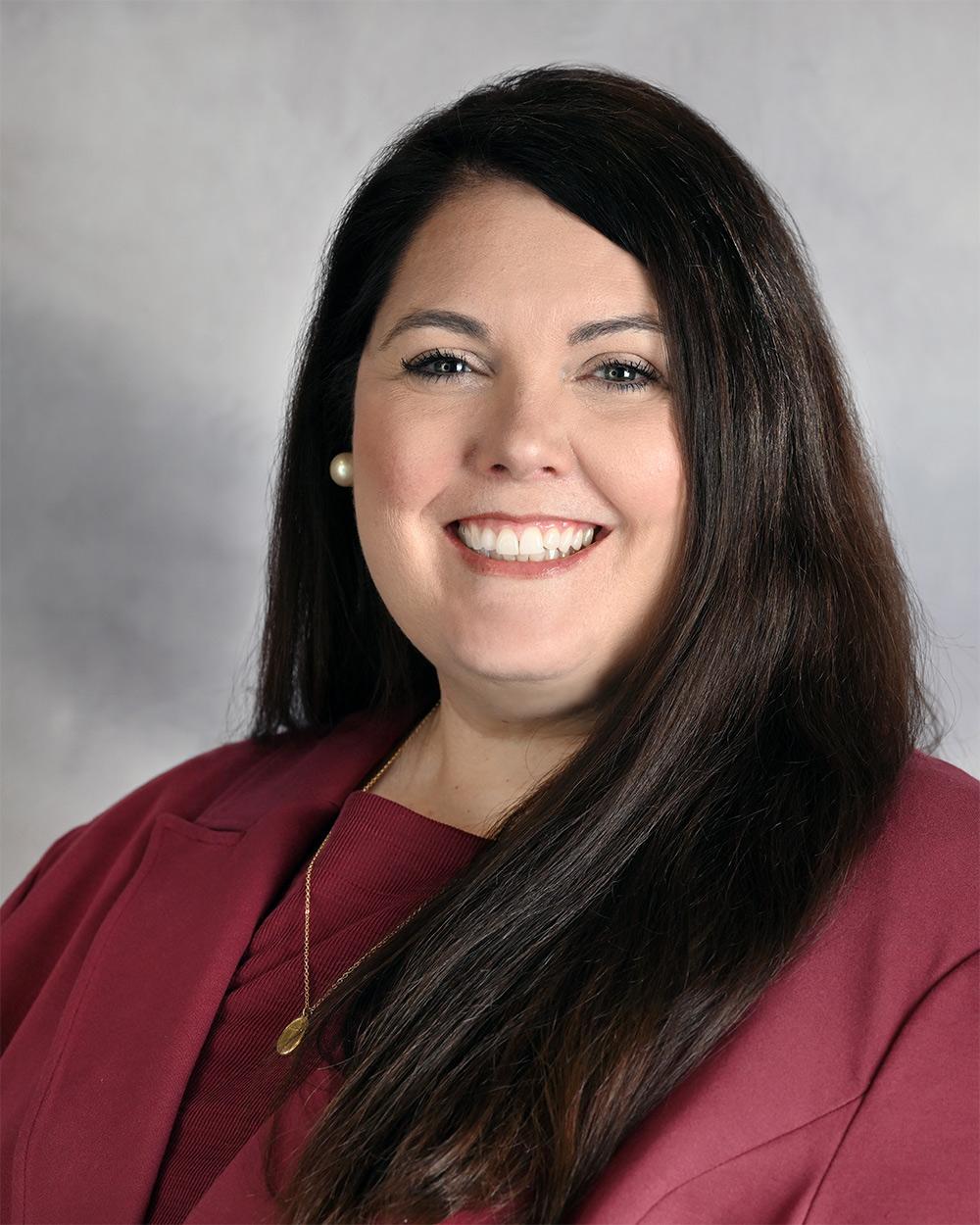 Portrait of Sarah Beth Cooper (Photo by Marianne Todd) with dark hair wearing a maroon top.